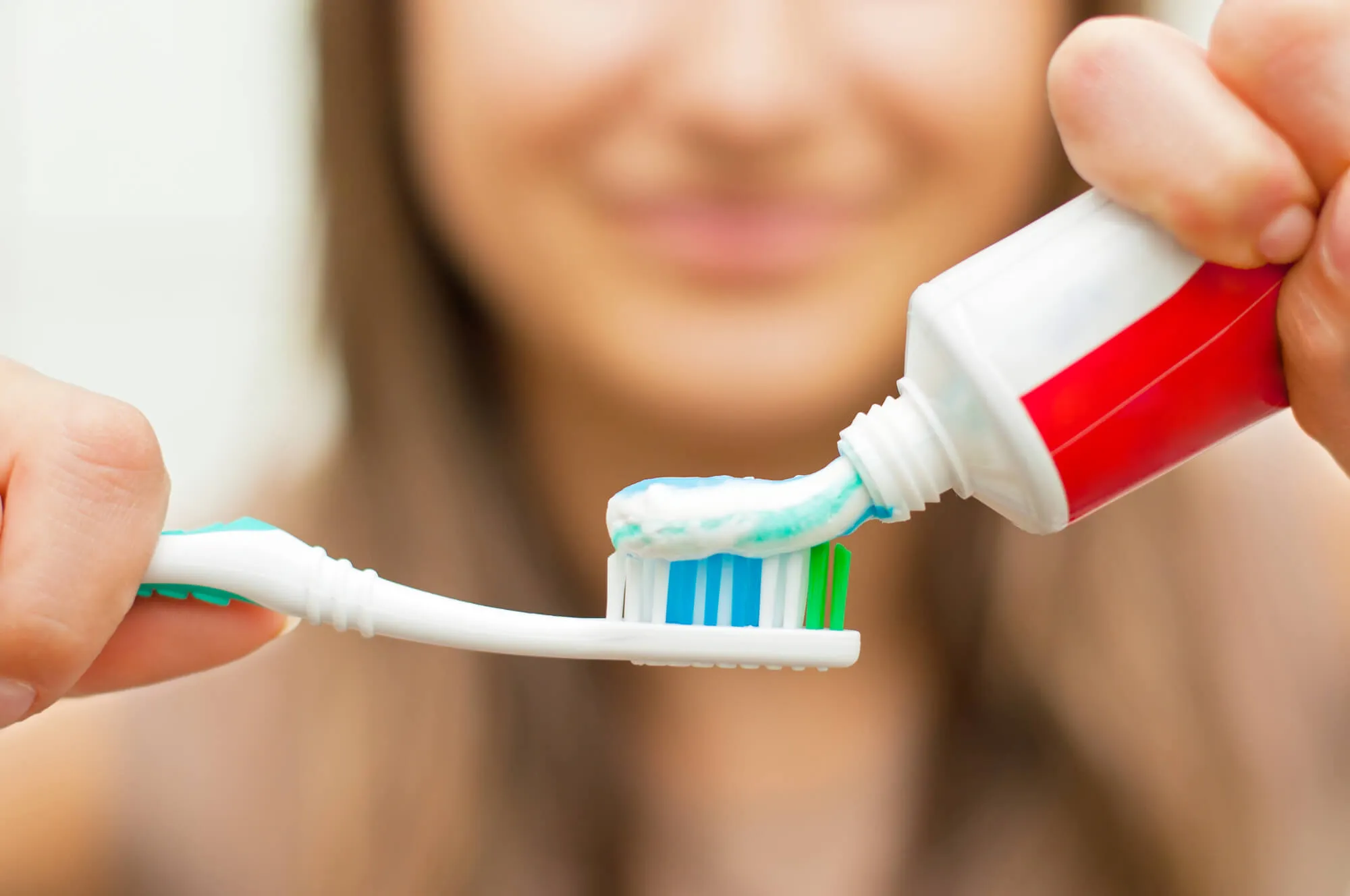 woman brushing her teeth with home care instructions